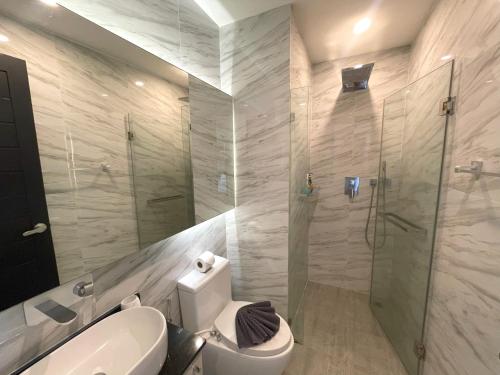 uma casa de banho com um WC e uma cabina de duche em vidro. em Sea view apartment at Oceana by Lofty em Kamala Beach