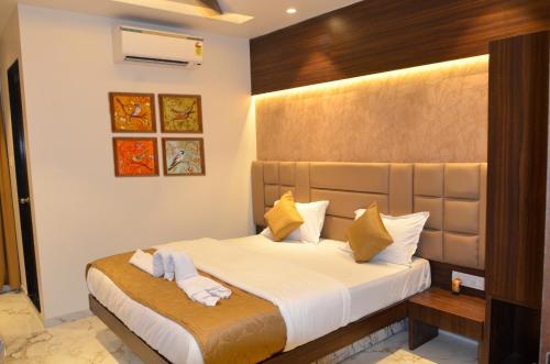 a bedroom with a bed with white sheets and pillows at Ritvik Residency in Navi Mumbai