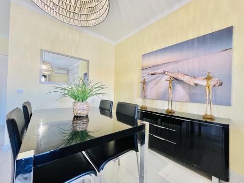 a dining room with a glass table and a giraffe painting at Lavanda - 2 Bedrooms - 3 Level Pool - Garden - Beach 1km in Estômbar