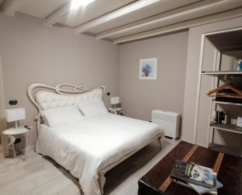 a bedroom with a white bed and a table at Casale Raffaello B&B Como in Albese Con Cassano