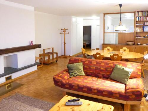 ein Wohnzimmer mit einem Sofa und einem Tisch in der Unterkunft Apartment Genziana by Interhome in Crans-Montana