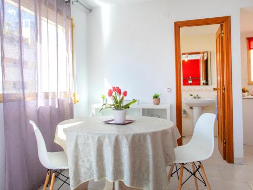 a white table with a vase of flowers on it at Studio Apolo VI-4 by Interhome in Calpe