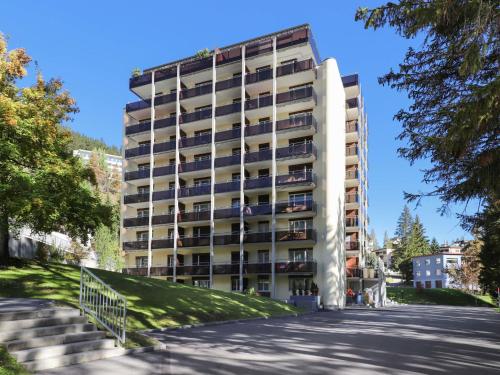 a tall apartment building with a parking lot at Apartment Allod Park Haus C 404 by Interhome in Davos