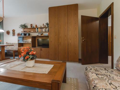 巴特霍夫加施泰因的住宿－Apartment Sun & Mountain View by Interhome，客厅配有带鲜花的咖啡桌