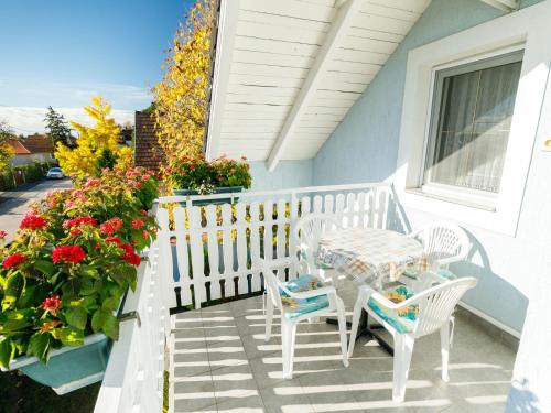un porche blanco con mesa, sillas y flores en Apartment Gerania by Interhome, en Balatonfüred