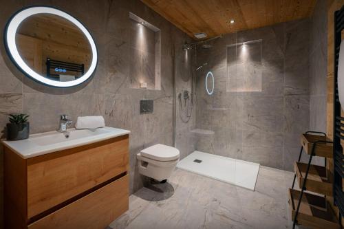 a bathroom with a toilet and a sink and a mirror at Chalet Q - OVO Network in Châtel