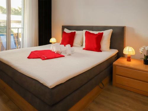 a bedroom with a bed with red and white pillows at Apartment Allod-Park-6 by Interhome in Davos