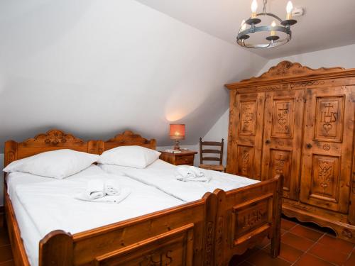 ein Schlafzimmer mit einem großen Holzbett mit weißer Bettwäsche in der Unterkunft Holiday Home Sonnenschein by Interhome in Norddeich