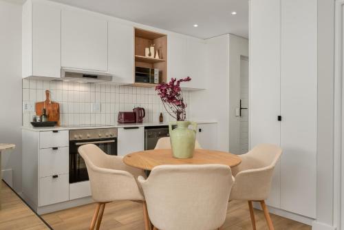 a kitchen with a wooden table and chairs at Suro Luxury Apartments in Cape Town
