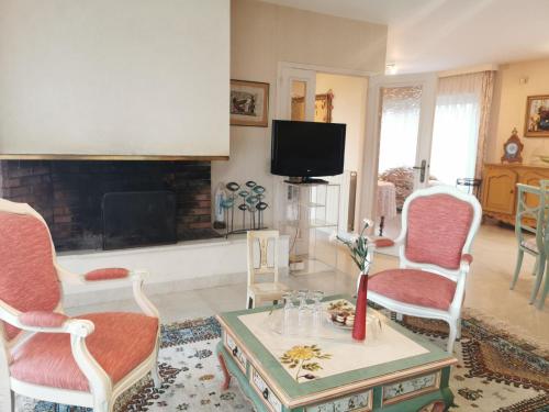 a living room with two chairs and a fireplace at Holiday Home Les Rimains by Interhome in Cancale