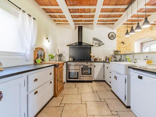 une grande cuisine avec des placards blancs et une cuisinière dans l'établissement Holiday Home Le Mas des Buis by Interhome, à Uchaux