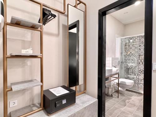 a bathroom with a toilet and a mirror at Bazaar Boutique Residence in Budapest