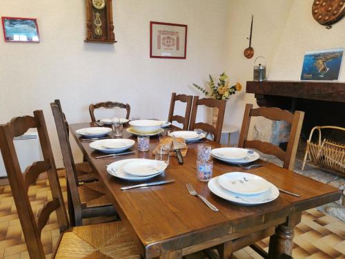 une table en bois avec des assiettes et des ustensiles dessus dans l'établissement Holiday Home La maison bleue by Interhome, à Cancale