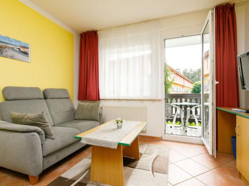 a living room with a couch and a table at Apartment Dünenhaus App- 104 by Interhome in Zempin