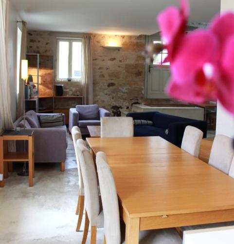un salon avec une table et des chaises en bois dans l'établissement Gîtes de la Grande Ferme, à Avernes