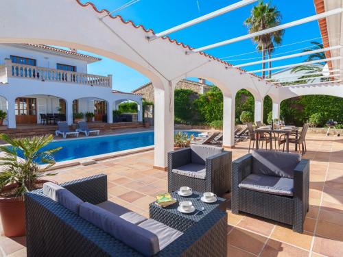 patio z krzesłami i stołami oraz basenem w obiekcie Apartment Ana II by Interhome w mieście Cala Murada