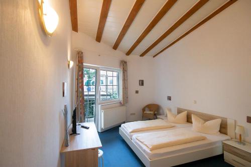 a bedroom with two beds and a window at Hotel Dolgesheim in Dolgesheim