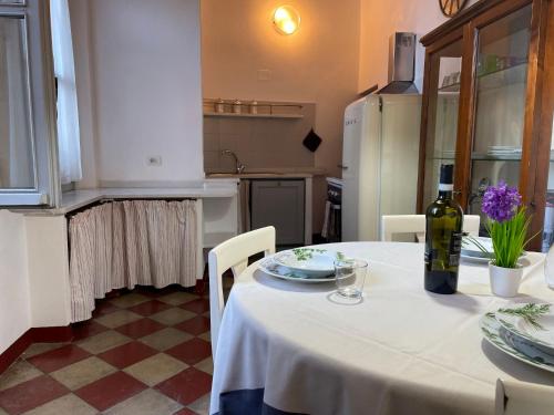 una cucina con tavolo bianco e una bottiglia di vino di Apartment Merlino - FLG207 by Interhome a Finale Ligure