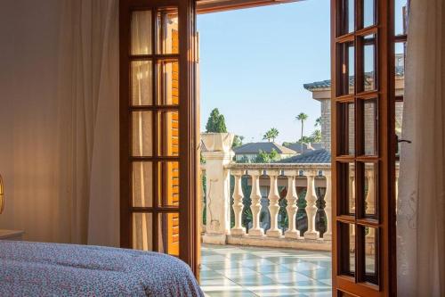 1 dormitorio con cama y vistas a un balcón en villa costa blanca, privada para 12 personas y cerca playa Muchavista, en San Juan de Alicante
