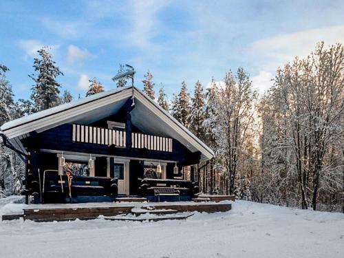 a log cabin in the snow with trees at Holiday Home Vaaranpää by Interhome in Meltaus