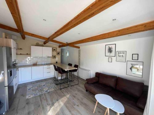 Il dispose d'une cuisine et d'un salon avec un canapé et une table. dans l'établissement Maison plain pied au calme, à Cuges-les-Pins