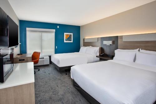 a hotel room with two beds and a desk at Holiday Inn Express Kitty Hawk - Outer Banks by IHG in Kitty Hawk