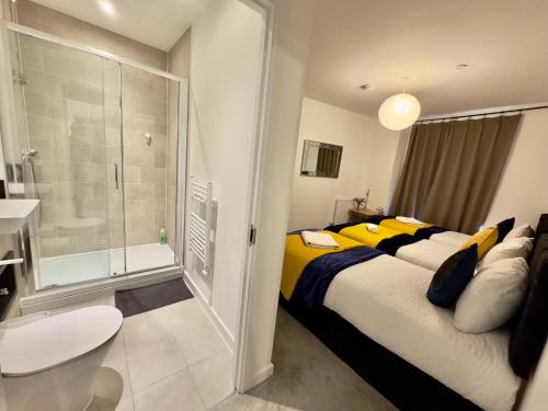 um quarto com uma cama grande e almofadas amarelas em 3Bedroom, 2Bathroom, Balcony,Luxury Flat Westfield em Londres
