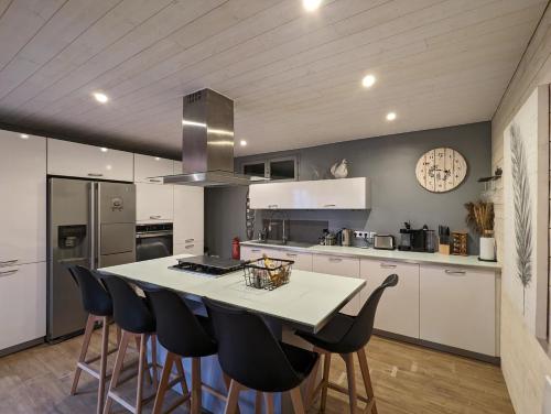 a kitchen with a table and some black chairs at Les Myrtilles, appartement au pied des pistes in Saint-Pierre-dels-Forcats