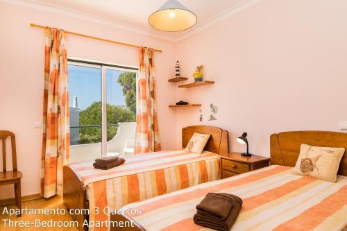 Dos camas en una habitación con ventana. en Akisol Albufeira Sunny, en Roja- Pé