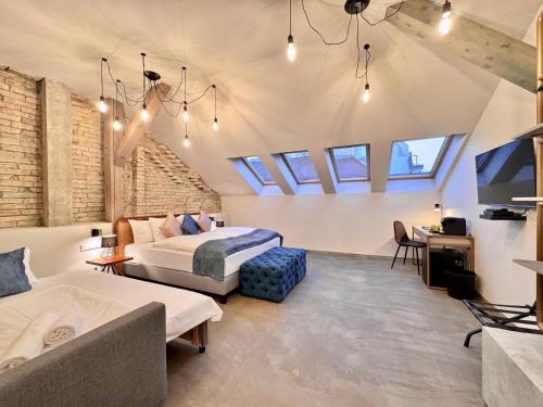 a bedroom with two beds and a couch and a tv at Bazaar Boutique Residence in Budapest