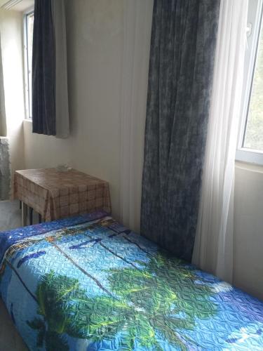 a bedroom with a bed and a window and a table at Family Hotel "Big House" in Kobuleti