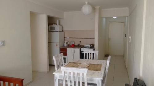 a kitchen with a table and chairs and a refrigerator at Temporario V sol in Córdoba