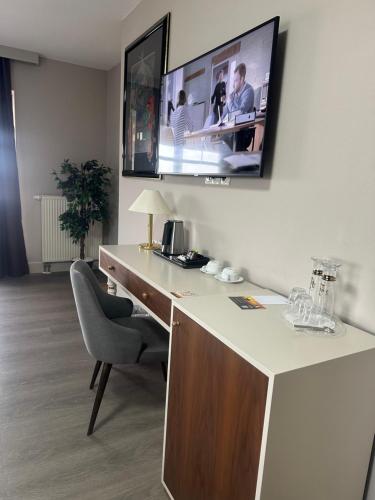 a room with a desk with a tv on the wall at City Hotel Frankfurt Bad Vilbel in Bad Vilbel