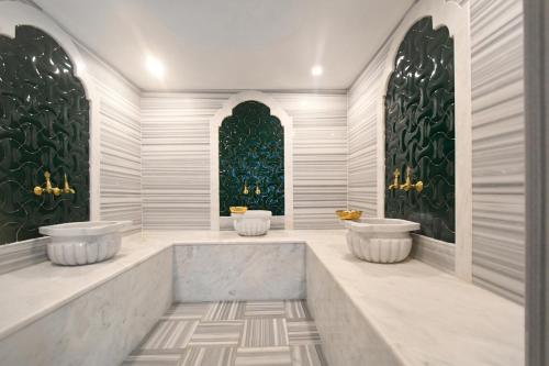 a bathroom with two sinks in a room with green walls at Litore 1 room 200 m sea in Alanya