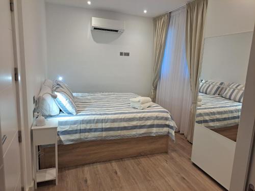 um pequeno quarto com uma cama e uma janela em Main Street - 3 Bed Room - Family Friendly em Gibraltar