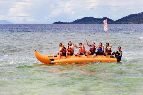 a group of people riding on an orange raft in the water at POP! Hotel Tanjung Karang in Bandar Lampung