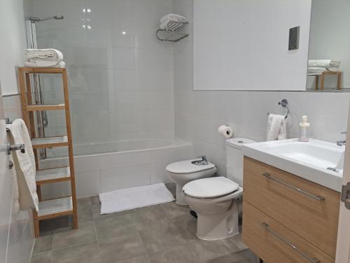 a white bathroom with a toilet and a sink at Main Street - 3 Bed Room - Family Friendly in Gibraltar