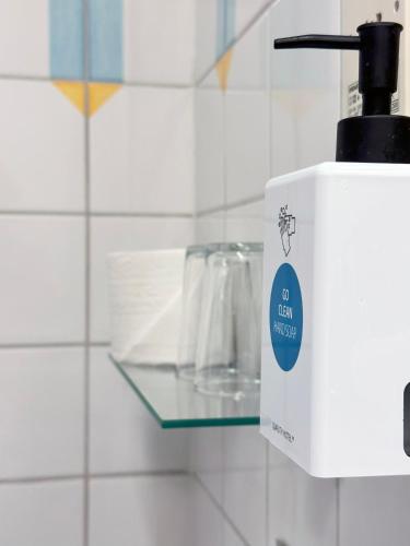 a soap dispenser on a glass shelf in a bathroom at Quality Hotel Galaxen in Borlänge