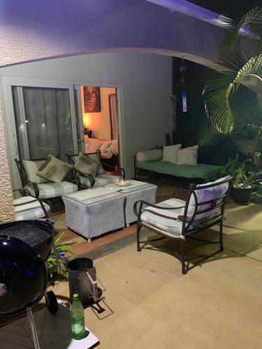 a living room with couches and chairs in a room at Jay&Kay CosyRoom FlicEnFlac in Flic-en-Flac