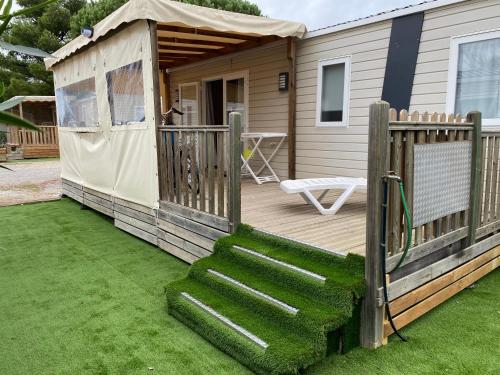 a house with a deck with a gazebo at Mobil Home Luxe 3 chambres climatisé Canet en Roussillon in Canet-en-Roussillon