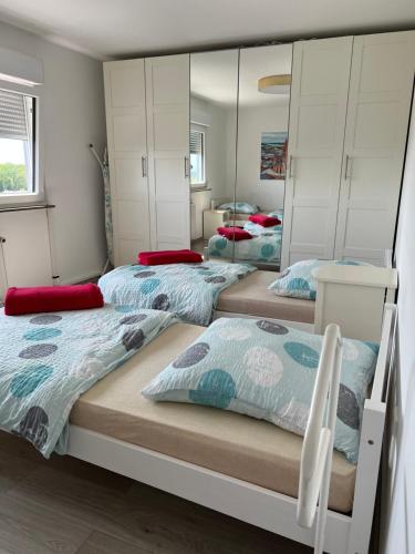three beds in a room with mirrors at Apartment in Mainz-Lerchenberg in Mainz