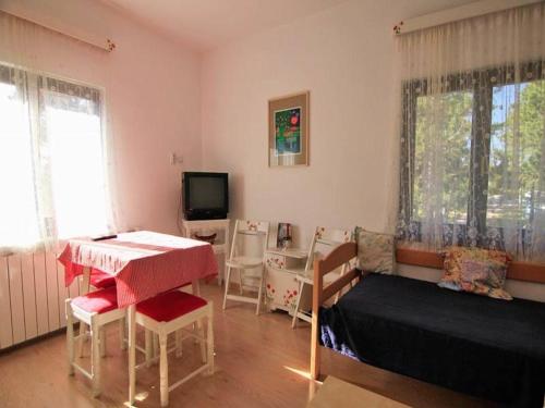 a room with a table and a bed and a television at Guest House 3M in Kaludjerske Bare