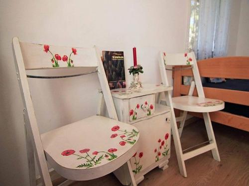 a room with two chairs and a table with flowers on them at Guest House 3M in Kaludjerske Bare