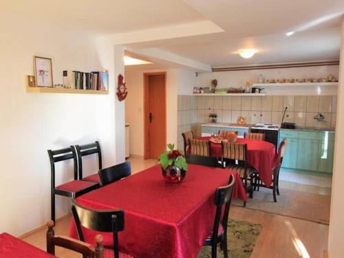 una sala da pranzo con tavolo e sedie e una cucina di Guest House 3M a Kaludjerske Bare