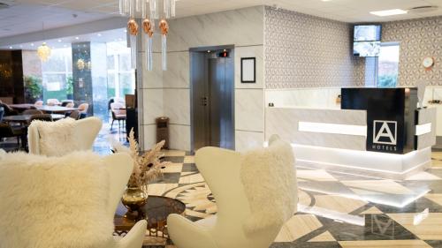 a lobby with white chairs and a table in a building at A Hotels Glostrup in Glostrup