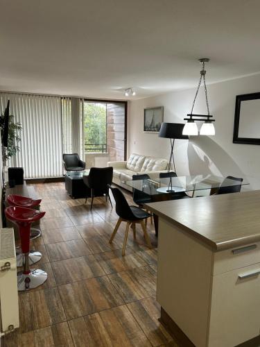 a living room with a couch and a table and chairs at Condominio Costa Pucon in Pucón