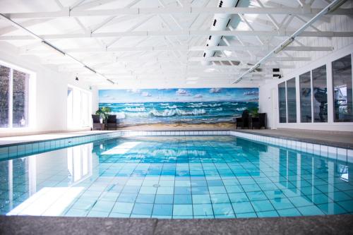 a swimming pool with a mural of the ocean at Hotel Tannishus in Bindslev