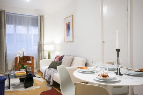 Perfectly located 1 bed apartment above tube station في لندن: غرفة معيشة مع طاولة بيضاء وأريكة