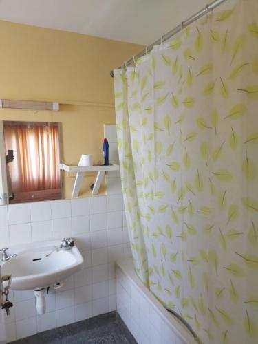 a bathroom with a shower curtain with a sink at Mrembo Lovely Nest in Nairobi
