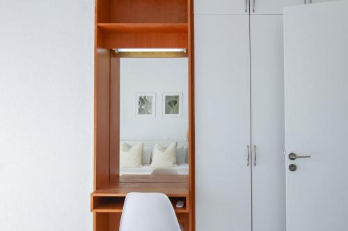 a bedroom with a mirror and a white chair at Phaedrus Living Azure Serenity Villa in Khlorakas